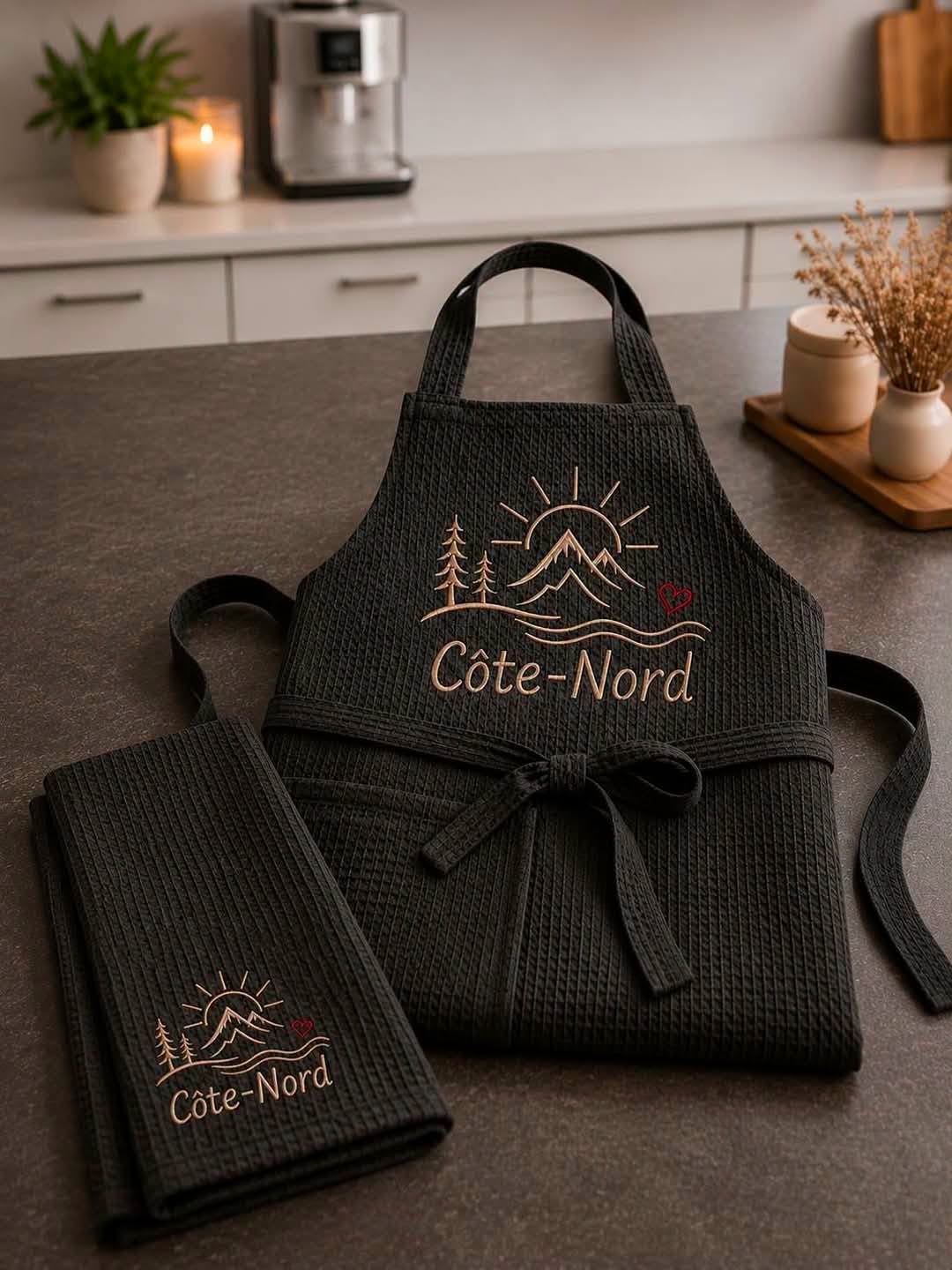 Tablier noir texturé Côte-Nord avec linge assorti, logo brodé épinettes montagnes et fleuve